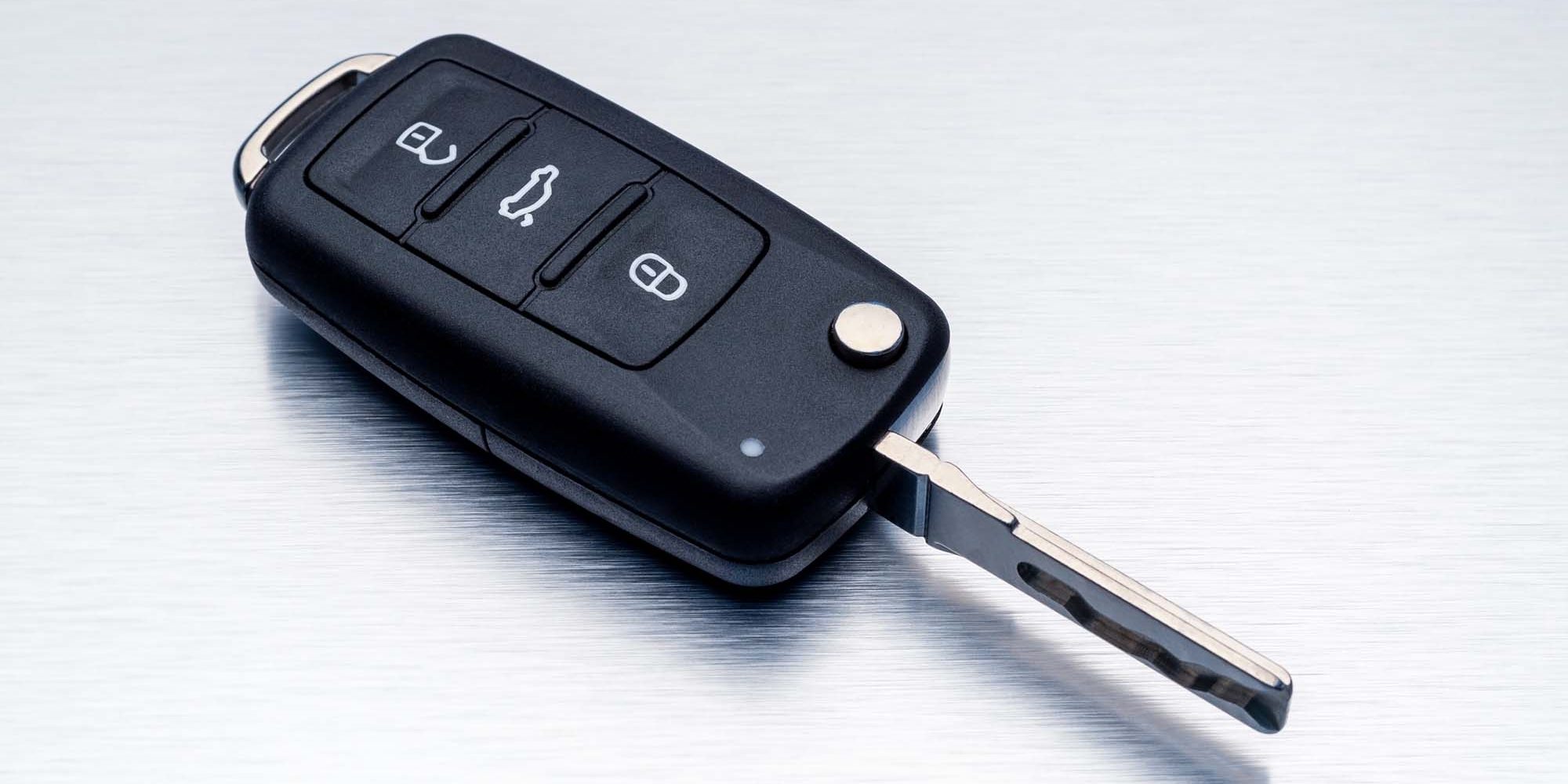 New car key fob on aluminium background. Repair of broken or damaged remote key fob of any vehicle car service concept.- Image